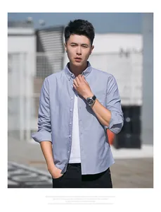 Detailed shot of a men's light blue Oxford button-down long-sleeved shirt outdoors.