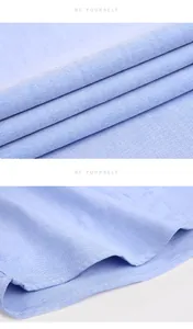 Detailed macro view of light blue Oxford fabric and hem stitching for men's long sleeve shirt