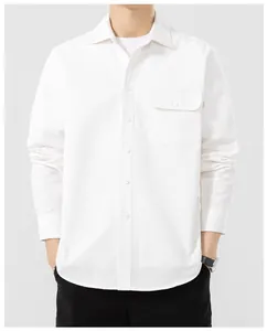 Detail of a white cotton long-sleeve shirt featuring a functional buttoned chest pocket