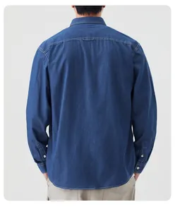 Vista posteriore di una camicia in denim blu a maniche lunghe con cuciture a contrasto