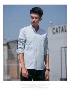 Men's light green striped oxford long-sleeve shirt styled in an urban outdoor setting
