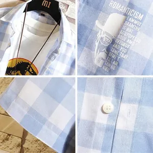 Light blue plaid men's casual short sleeve shirt featuring white button details