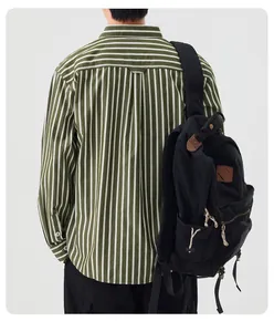Detailed back view of a men's green striped long-sleeve shirt with a black canvas backpack.