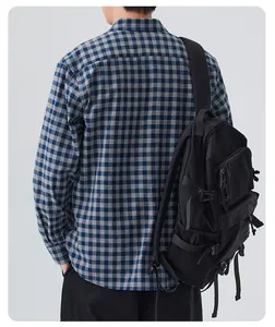 Back view of a man wearing a blue checkered casual long-sleeved shirt with a backpack