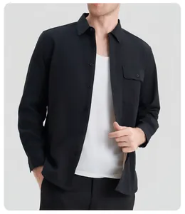 Professional detail view of men's black long sleeve shirt with chest pocket on model