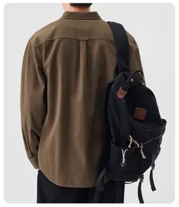 Detailed back view of a casual brown long-sleeved shirt for men worn with a backpack