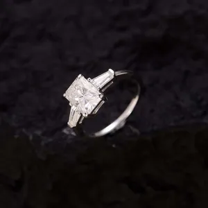 Close-up van moissaniet ring met radiant slijpvorm en baguette zijstenen op rots