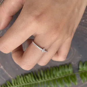 Close-up of a minimalist S925 silver cross ring with moissanite stones worn on a hand