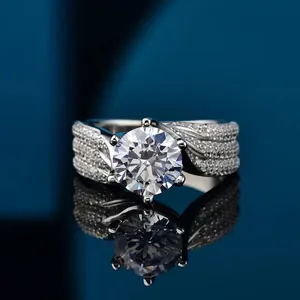 Luxe 5-karaats moissaniet ring met pavé-band op een reflecterende blauwe ondergrond.
