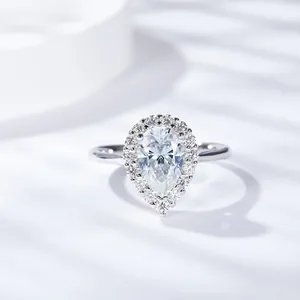 Vue rapprochée d'une bague en moissanite en forme de poire avec halo sur fond blanc.