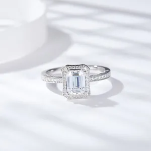 Detalle de un anillo de moissanita talla esmeralda con halo y banda de pavé de diamantes