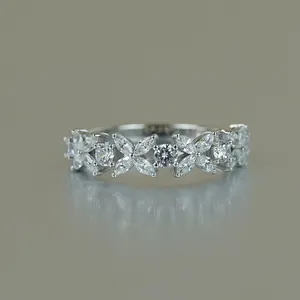 Close-up of sparkling marquise-cut moissanite stones in a clover pattern on silver ring