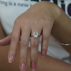 Détail d'une bague en Moissanite en forme de poire avec sertissage halo sur la main