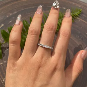Detailansicht eines Baguette-Moissanit-Eternity-Rings aus S925-Sterlingsilber am Finger.
