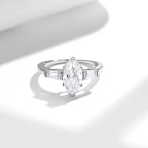 Detail shot of marquise cut moissanite ring with baguette side stones in silver.
