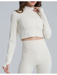 Dettaglio della giacca da yoga crema slim-fit da donna con fori per il pollice e zip.