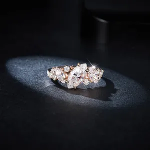 Close-up of a marquise cut moissanite ring with rose gold plating in spotlight
