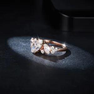 Close-up of elegant rose gold marquise moissanite ring on a black background