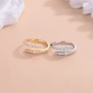 Primer plano de elegantes anillos abiertos de moissanita de doble fila en oro y plata