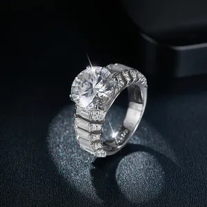 Macro shot of a 5ct round moissanite ring with baguette side diamonds on black background.