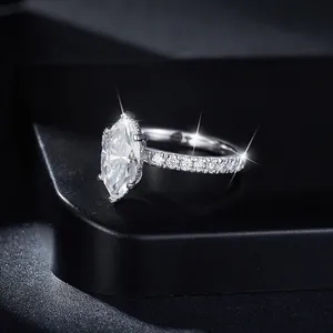 Primer plano de un anillo de moissanita talla marquesa de 2ct con piedras laterales.