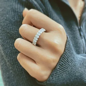 Close-up of an elegant women's sterling silver oval-cut moissanite eternity wedding ring