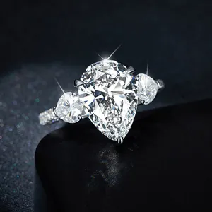 Detalle de anillo de moissanita con forma de pera y piedras laterales en plata de ley 925.