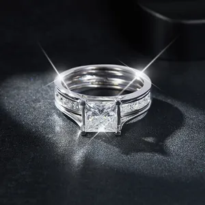 Primer plano de un anillo de moissanita de corte princesa de 6,5 mm con banda de plata.