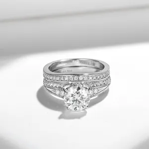 Detalle del juego de anillos vintage con moissanita redonda de 1,5 ct y borde milgrain.