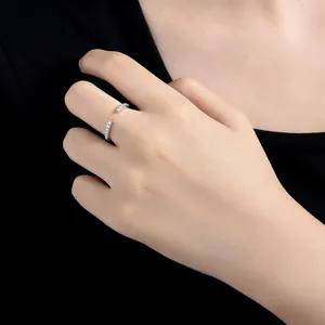 Close-up detail showing a minimalist moissanite open ring worn on a female finger