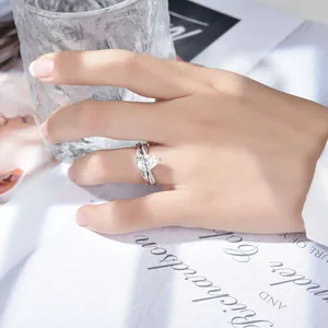 Close-up of a pear-shaped moissanite ring worn on a hand, showing sparkle