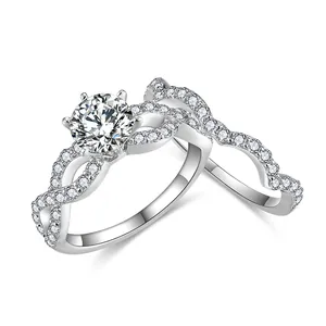 Set di anelli in moissanite tonda da 1 carato con fascia pavé ondulata in finitura argento.