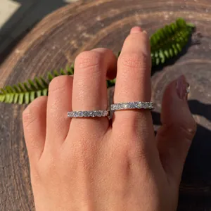Detailed shot showing two elegant 3.0mm moissanite eternity wedding rings on a hand