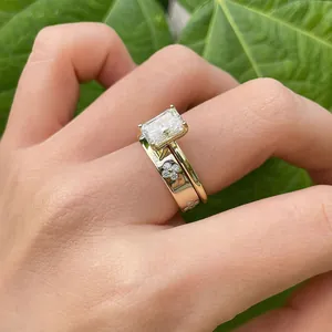 Vista detallada del conjunto de anillos de novia de moissanita y trébol en color oro
