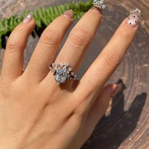 Detail view of oval cut moissanite star and moon silver wedding ring set on a hand