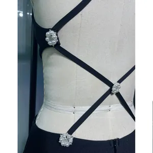Dettaglio di un abito a fascia con schiena scoperta e eleganti fiori di perle sulle spalline.
