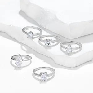 Primer plano de cinco cortes de anillos de compromiso de moissanita en piedra blanca