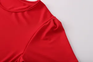 Close-up detail showing the round neckline and shoulder seam of a vibrant red dress