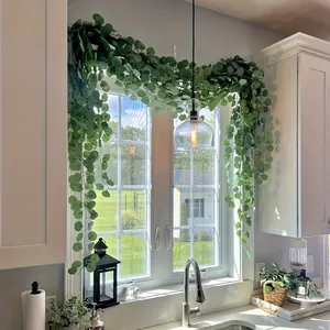 Detailed view of artificial eucalyptus garland hanging over a bright kitchen window