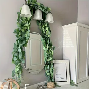 Lush green artificial eucalyptus garland draped over a modern bathroom mirror frame