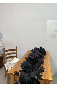 Vista dettagliata della ghirlanda di foglie di acero nero con bacche rosse su tavolo.