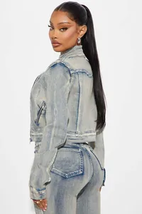 Detailed side view of washed blue denim jacket and jeans set on fashion model wear