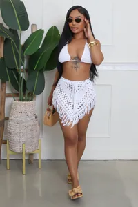 Dettaglio di un completo due pezzi in crochet fatto a mano bianco con nappe e trafori