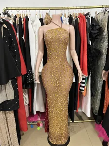 Exquisite detail of sparkling gold rhinestones on a high-end nude mesh evening gown