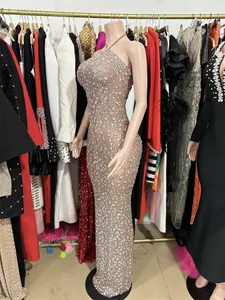 Close-up of heavy sparkling rhinestone embellishments on a nude mesh backless evening dress