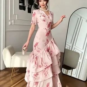Vue détaillée des volants et de l'imprimé floral sur une robe longue rose à col en V.