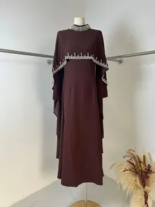Detail view of burgundy long dress featuring an elegant rhinestone beaded cape overlay.