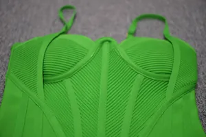 Close-up of bright green bandage bodycon dress showing ribbed texture and corset detail