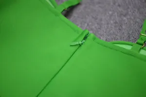 Close-up detail of the smooth back zipper on a vibrant green bodycon bandage dress