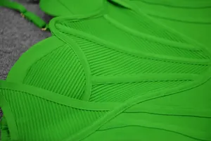Close-up macro shot showing the premium ribbed texture and stitching of a green bandage dress